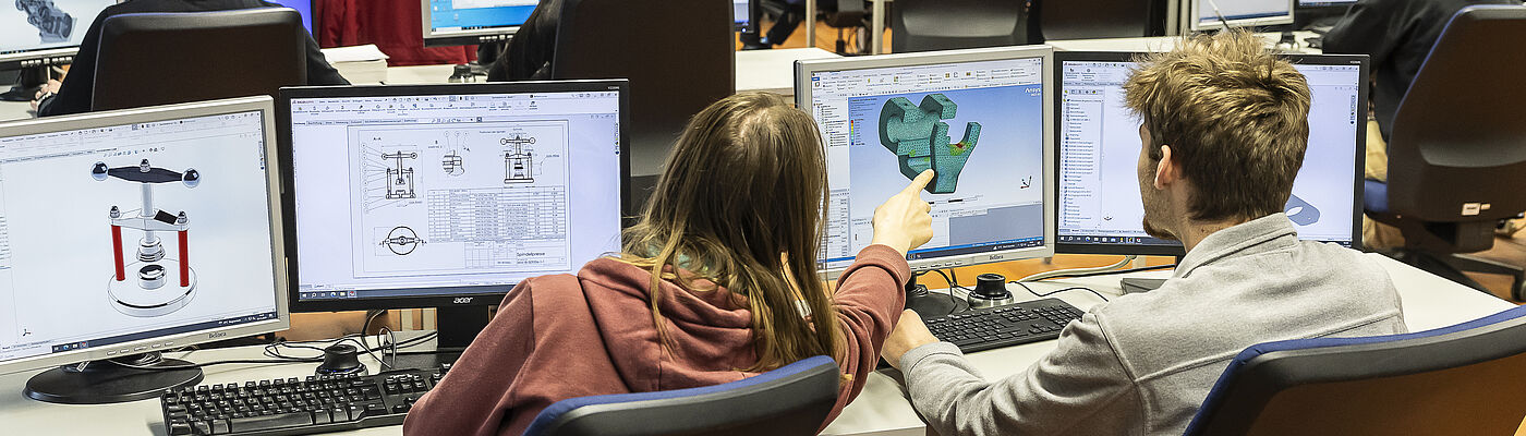 Studierende in einem Seminarraum vor einem PC-Bildschirm