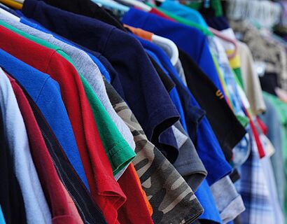 Verschiedene Kleidungsstücke auf Bügeln