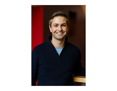 Porträt Valentin Burgert vor rotem Hintergrund