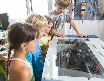 Kinder arbeiten und entdecken die Möglichkeiten des Lasercutters