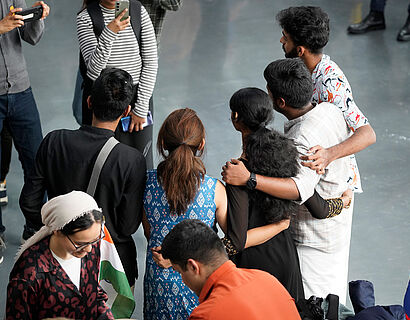 Teilnehmende des Internationalen Nachmittags stehen sich umarmend in einem Halbkreis nebeneinander