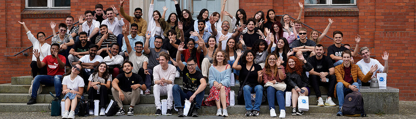 Internationale Studierende beim Gruppenfoto auf der Treppe von Haus 13 im Rahmen der Orientierungswoche für das Wintersemester 23/24