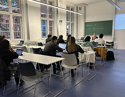 Seminarraum, in dem Studierende von hinten zu sehen sind