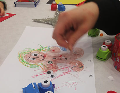 Kinderhand und gemaltes Bild auf dem Tisch