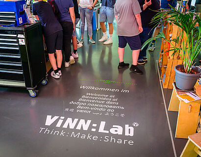 Bild des Schriftzugs "ViNN:Lab" auf dem Fußboden. 