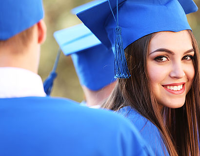Studierende in blauer Graduiertengarderobe