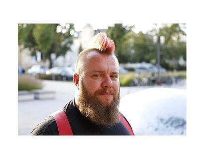 Porträt von Lars Bergmann vor verschwommenem Hintergrund.