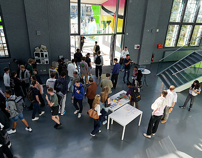 Studierende im Foyer eines Hörsaalgebäudes von oben fotografiert